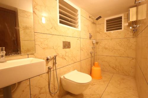 a bathroom with a toilet and a sink at Princess Bungalow Stay Madurai in Tirupparangunram