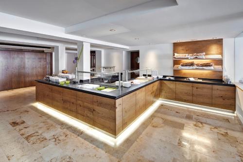 a large kitchen with a counter in a room at Hotel Krone in Dornbirn