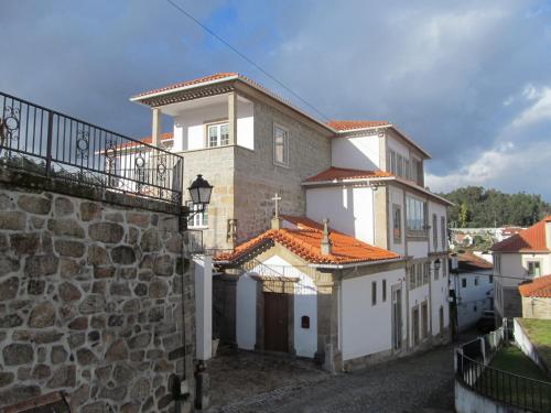 una grande casa bianca con un muro di pietra di Hotel Solar da Capela a Termas de São Pedro do Sul