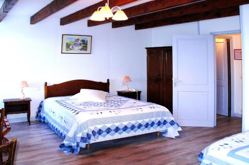 a bedroom with a large bed and a wooden floor at Le Fenelon in Carennac