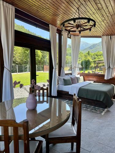 a bedroom with a bed and a table and a bed and window at The Heaven Sibiu in Sebeşu de Sus