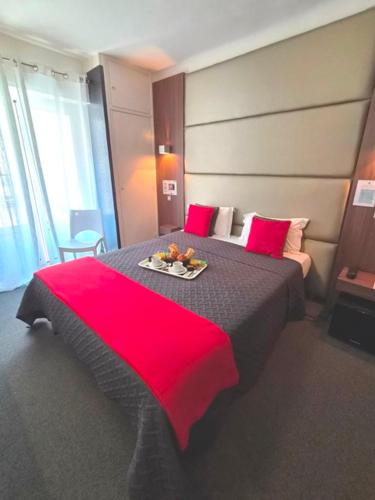 a bedroom with a large bed with a red blanket at Hotel Schtak in Cannes
