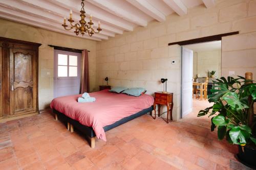 a bedroom with a large bed with a red blanket at L'Antre-neuf - 9p, piscine, arrivée autonome, wifi in Fontaine-Milon