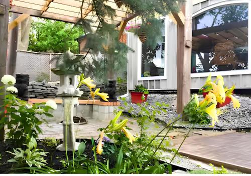 a garden with yellow flowers and a bird feeder at Peterborough Zen Retreat in Peterborough
