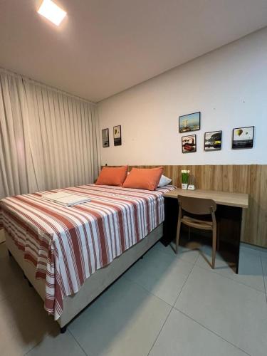 a bedroom with a bed and a desk with a chair at WestFit - Barreto - 709 in Mossoró