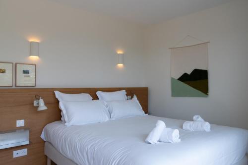 a bedroom with a large white bed with towels on it at Versants - La Croix Valmer in La Croix-Valmer