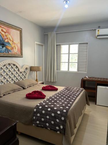 a bedroom with a bed with red pillows on it at Pousada e Museu JK in Ubajara