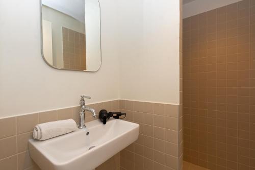 a white sink in a bathroom with a mirror at Versants - La Croix Valmer in La Croix-Valmer