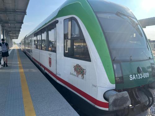 ein grün-weißer Zug an einem Bahnhof in der Unterkunft Metropol in Łomża