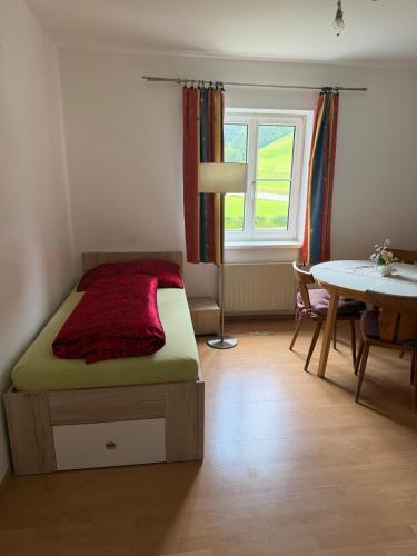 a bedroom with a bed and a table and a window at Wohnhaus Leitner in Wald am Schoberpaß