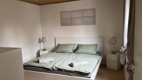 a white bedroom with a bed with two pillows at Ferienwohnung Nele in Heimbach