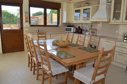 a kitchen with a wooden table and some chairs at Private beach villa Princess in Kiotari