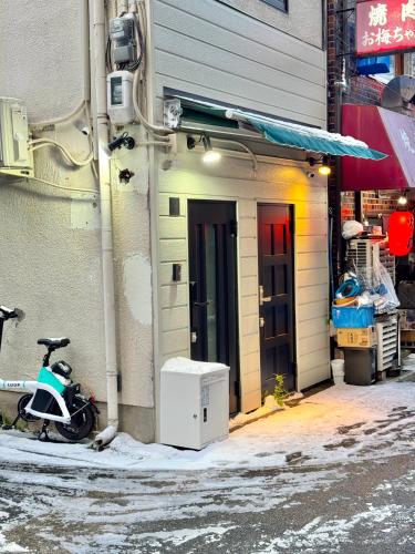 a motorcycle parked outside of a building next to a building at Maison Stay Kobe in Kobe