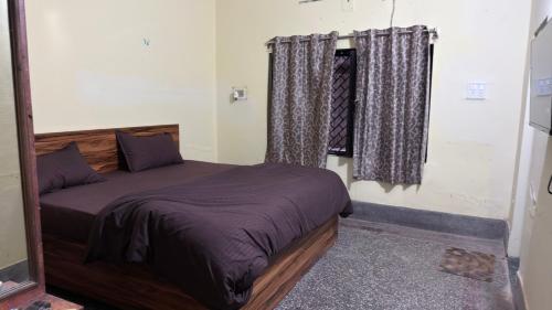 a bedroom with a bed and a window with curtains at Hotel Golden Pearl in Rewa