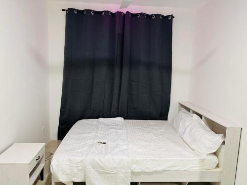 a bedroom with a bed with a black curtain at Twice Apartment in Hulhumale