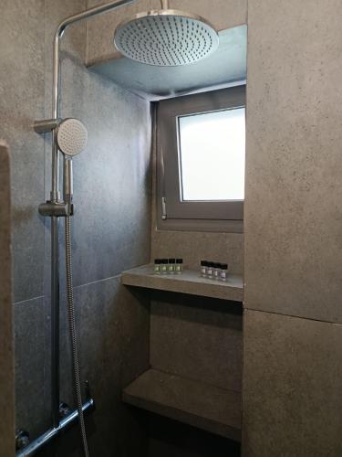 a bathroom with a shower with a window and a shower at Annousio 's house in Dhriopís