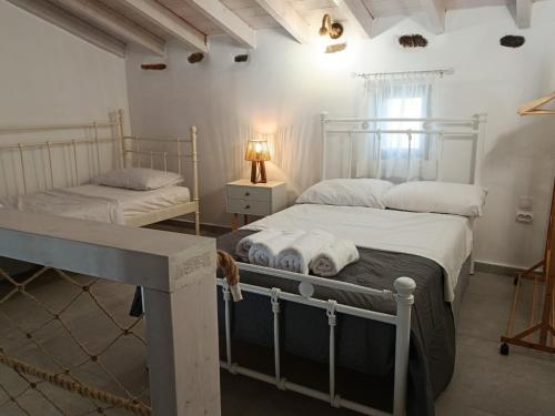 a bedroom with two beds and a lamp on a table at Annousio 's house in Dhriopís