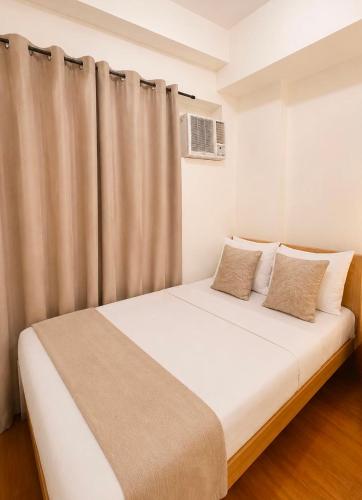 a bedroom with a white bed with a curtain at Camella Northpoint condominium in Davao City