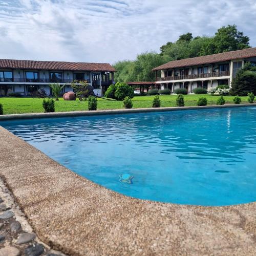 a swimming pool in front of a building at Hotel Casa De Campo in Santa Cruz