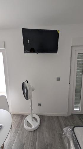 a white room with a fan and a tv on the wall at Praciña do olvido in Cee