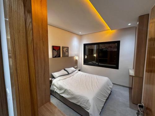 a bedroom with a bed in a room with avertisement at la perle d'el jadida in El Jadida