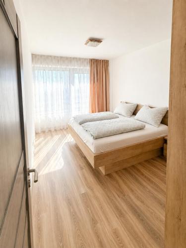 a bedroom with a bed and a large window at Apartment Centrum Orion in Dubnica nad Váhom