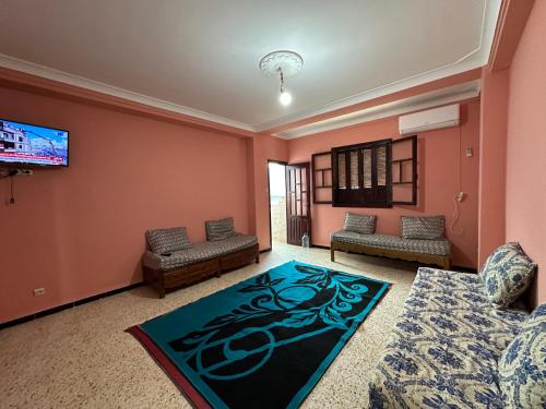 a living room with pink walls and a flat screen tv at el sahel residence in Beni Haoua