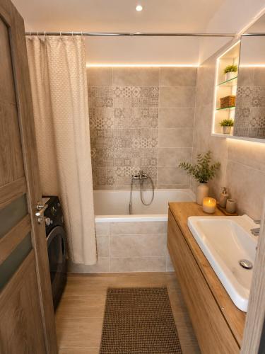 a bathroom with a tub and a sink at Apartment Centrum Orion in Dubnica nad Váhom
