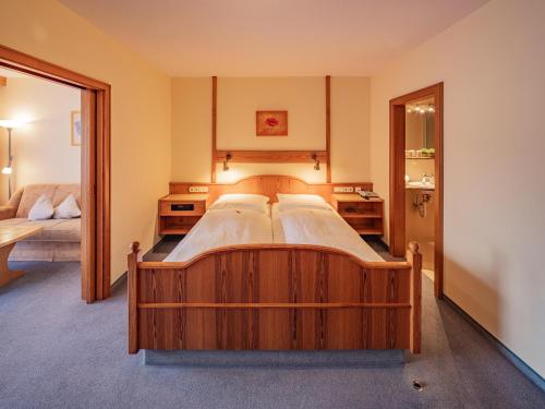 a bedroom with a large wooden bed in a room at Appartementhaus Holmernhof I in Bad Füssing