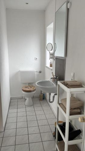 a white bathroom with a toilet and a sink at Ferienwohnung Nele in Heimbach