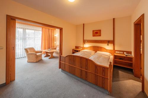 a bedroom with a bed and a living room at Appartementhaus Holmernhof I in Bad Füssing