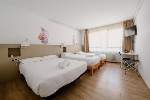 ein Hotelzimmer mit drei Betten und einem Fenster in der Unterkunft Hotel Terranova in Pas de la Casa