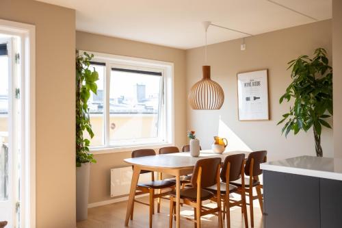 a dining room with a table and chairs at Modern 3 bedroom apartment - 4 minute walk from metro - top floor baclony view in Oslo