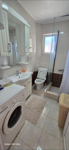 a bathroom with a washer and a toilet and a shower at Apartmani Seki in Bar