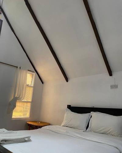 a bedroom with a white bed and a window at Riverside chania resort in Nyeri