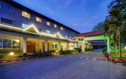 a hotel with a cobblestone street in front of a building at Ramee Guestline Hotel Bangalore in Attibele