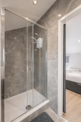 a shower with a glass door in a bathroom at Family & Group House | 3 Baths | Sleeps 12 in Banbury