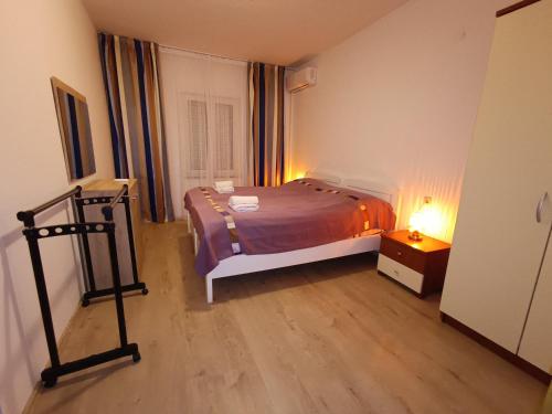 a small bedroom with a bed and a night stand at Obala Apartment & Studios in Malinska