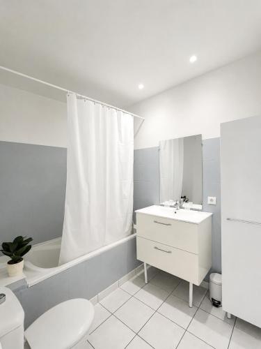 a bathroom with a sink and a toilet and a tub at Hôtel Saint Jacques in Sorède