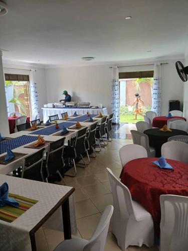 a dining room with tables and chairs and a person in the background at SolBlu Cottages in Kira