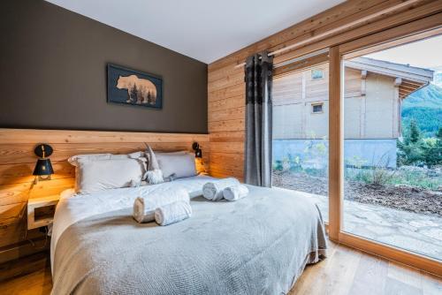 a bedroom with a bed and a large window at Malago in Le Monêtier-les-Bains