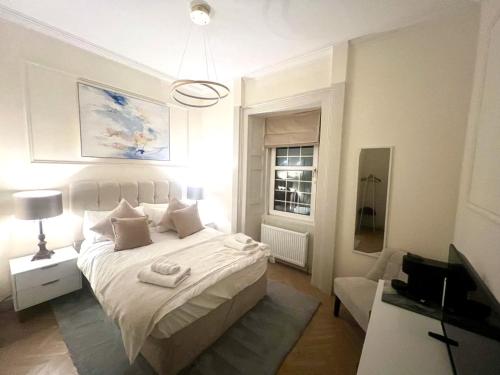 a bedroom with a white bed and a television at 'Maisie' in ApartNest Auchterarder in Auchterarder