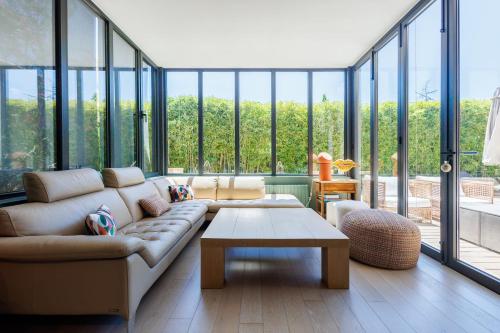 a living room with a couch and a table at Villa du Val - Welkeys in Aix-en-Provence