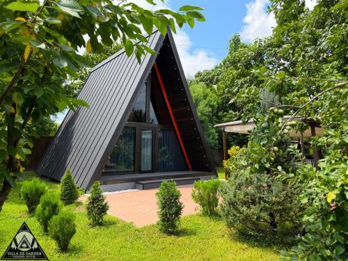 ein Haus mit dreieckigem Dach und Garten in der Unterkunft Garden Hotel in Kutaissi
