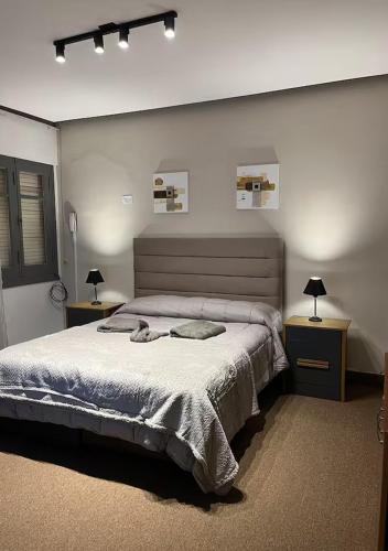 a bedroom with a large bed and two night stands at Lomar suite 2 - Depto céntrico Villa María in Villa María