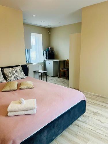 a bedroom with a pink bed with a towel on it at Straumes apartamenti in Valmiera