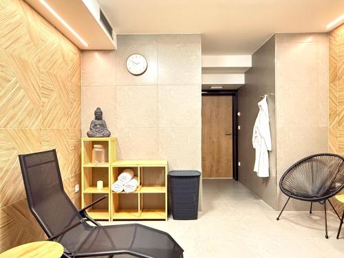 a room with a chair and a clock on the wall at Apartmány Perninský Dvůr in Pernink