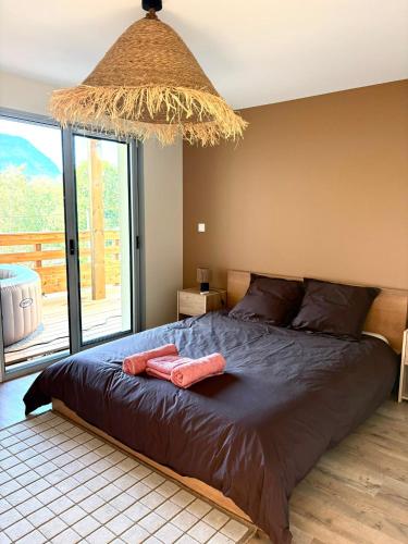 a bedroom with a bed and a large window at La Villa d'Aix - Entre lacs et montagne - Jacuzzi in Saint-Ours