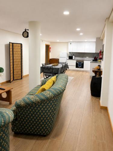 a living room with a couch and a kitchen at Dona Emília Mercado in Viana do Castelo
