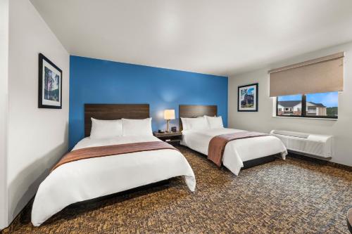 two beds in a hotel room with blue walls at My Place Hotel Twin Falls ID in Twin Falls